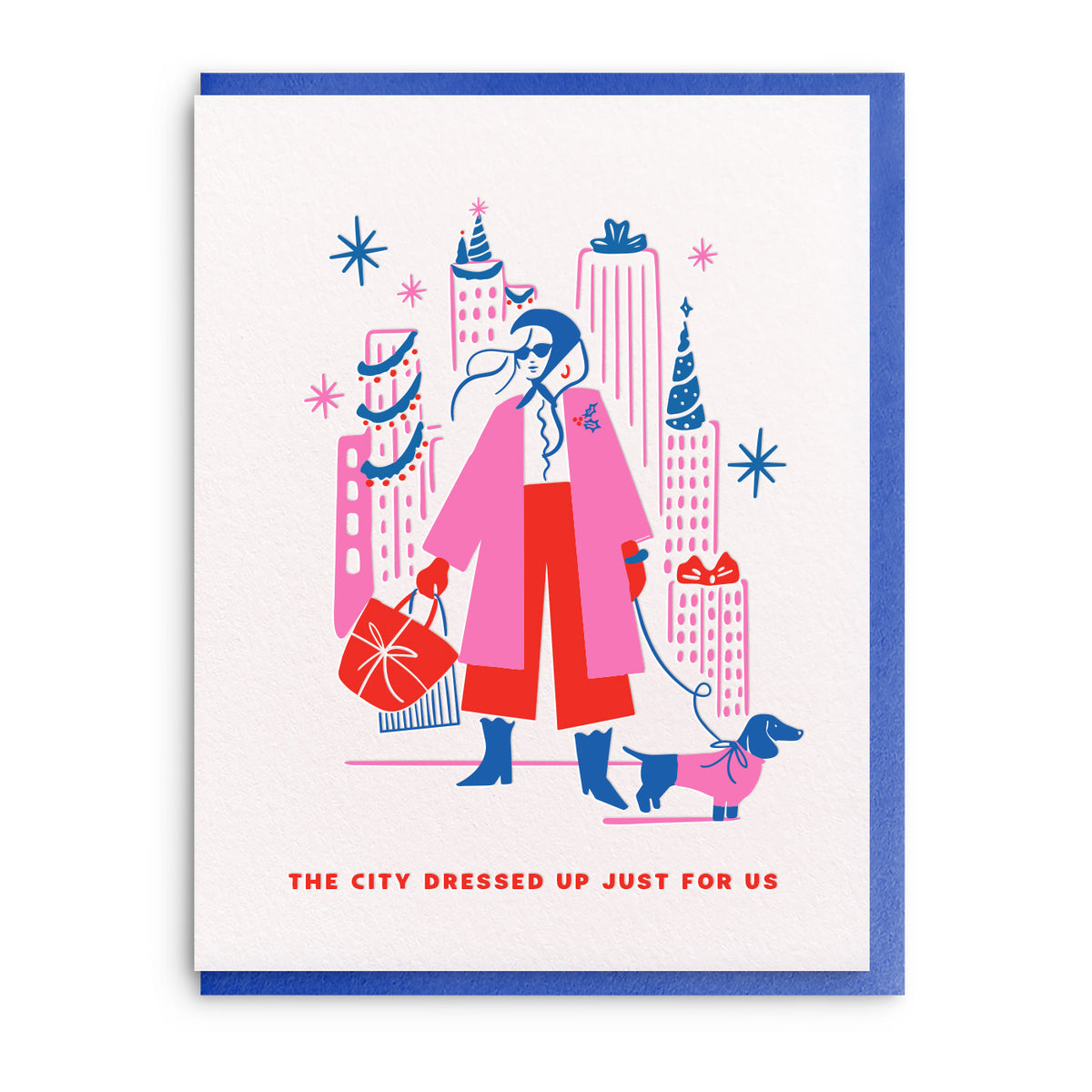 Illustration of a woman in a pink coat and red trousers walking a dachshund past tall city buildings trimmed for Christmas, with shopping bags on her arm.