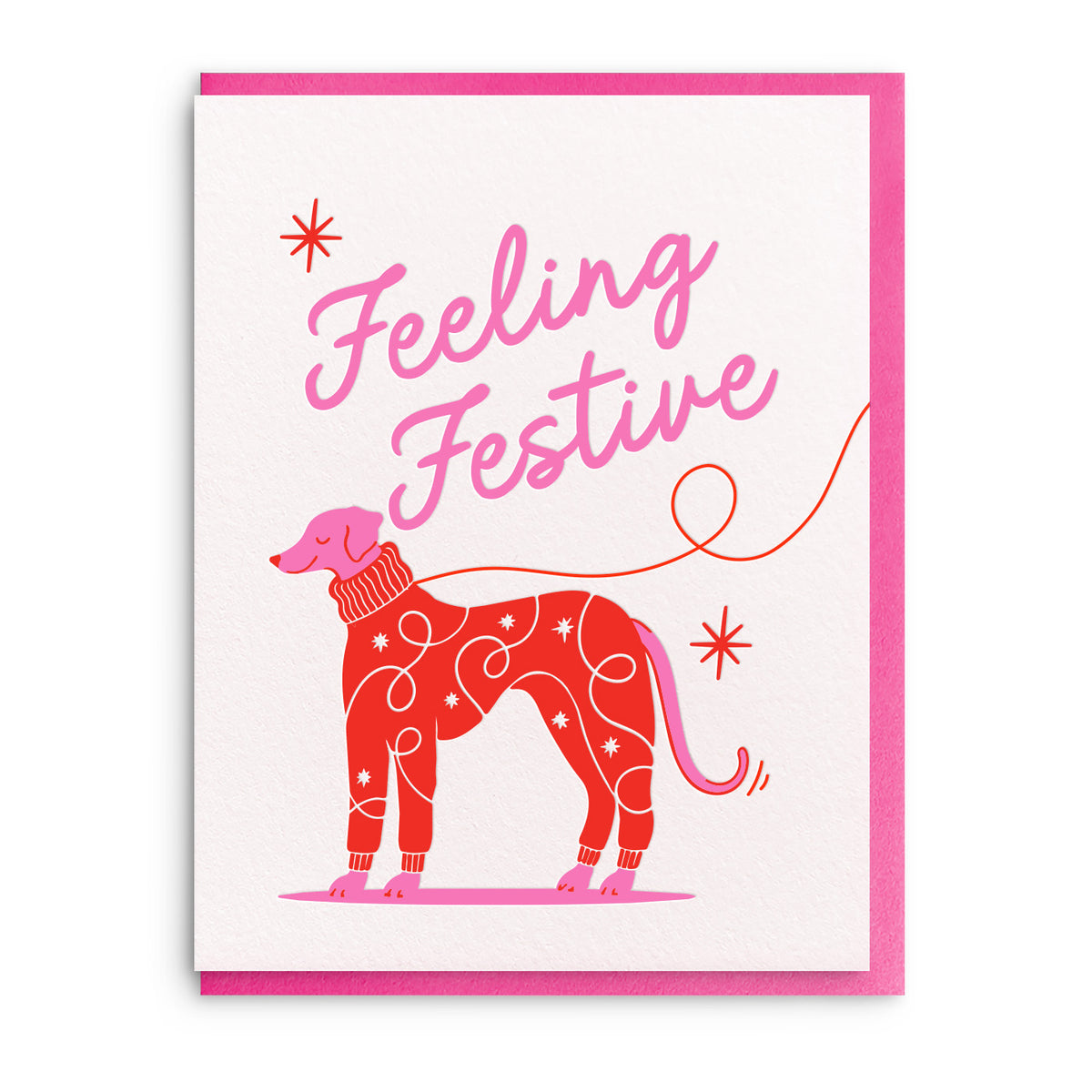 Red illustration of a spotted dog in festive decorations beside the words Feeling Festive in pink script, on a white card with a pink envelope.