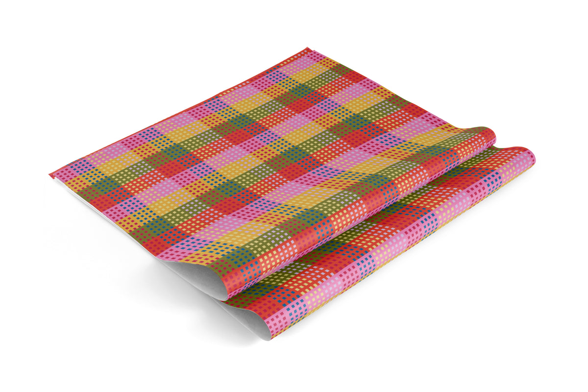 Gift wrap with a plaid pattern of overlapping squares in pink, orange, yellow, and green.